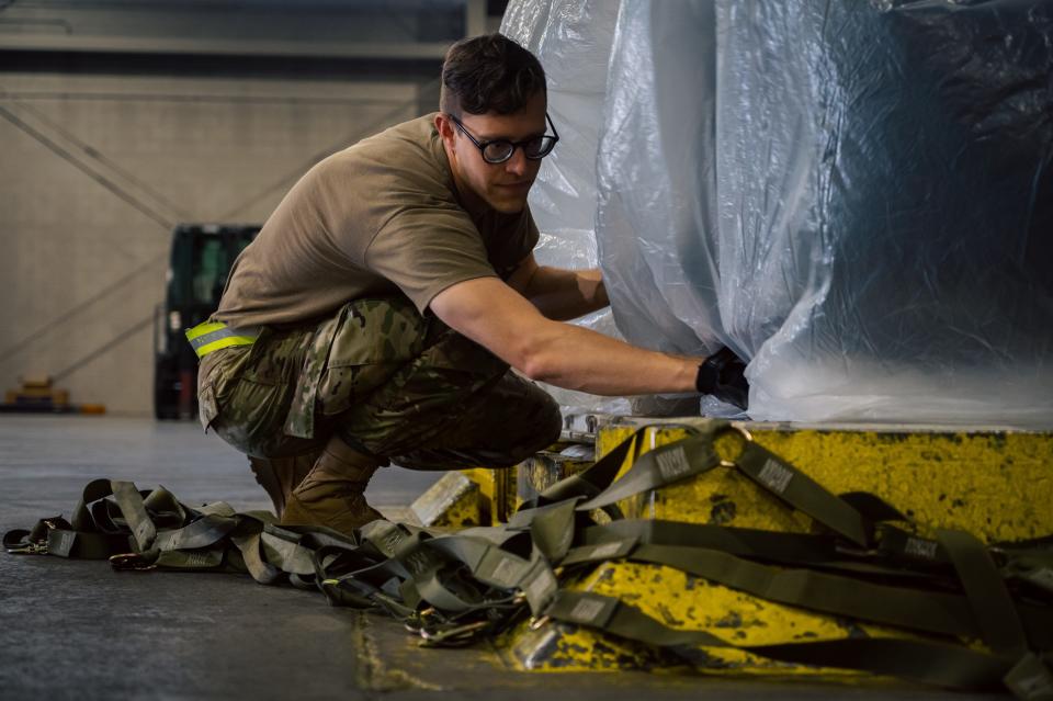 U.S. Air Force Staff Sgt. Patrick Chepaitis, 25th Aerial Port Squadron cargo specialist, secures a plastic covering over a cargo pallet on Joint Base McGuire-Dix-Lakehurst, New Jersey, June 9, 2022. The Reserve Airmen from the 25th APS, stationed at Maxwell Air Force Base, Alabama, trained with their active-duty counterparts to enhance mobility readiness in a total force environment.