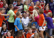 Children from public schools in the town of Chatfield, Minnesota, help U.S. President Barack Obama get up after he posed with them for a picture, during his bus trip to the Midwest August 15, 2011. Obama blasted Republicans over taxes on Monday as he launched a bus tour of the U.S. Midwest to tout his job-growth strategy and distance himself from anger toward Washington that could dent his 2012 re-election hopes. Obama is traveling on a bus tour through Minnesota, Iowa and Illinois. REUTERS/Jason Reed (UNITED STATES - Tags: POLITICS EDUCATION IMAGES OF THE DAY PROFILE)