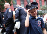 Six year-old Peter Samuelson wears a firefighter hat after a memorial service at Old St. Pat's Church to mark the tenth anniversary of the September 11 terror attacks on the World Trade Center on September 11, 2011 in New York City. New York City firefighters are commemorating the 10th anniversary of the 9/11 terrorist attacks and honoring the 343 firefighters who died in the line of duty. (Photo by Justin Sullivan/Getty Images)