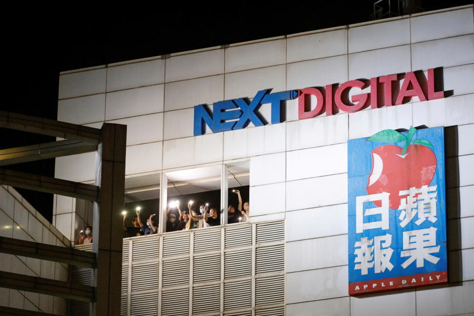 Journalists of Apple Daily wave to supporters at the headquarters of the Apple Daily newspaper, and its publisher Next Digital, after the announcement that the newspaper is folding its operations earlier, in Hong Kong, China June 23, 2021. REUTERS/Tyrone Siu     TPX IMAGES OF THE DAY
