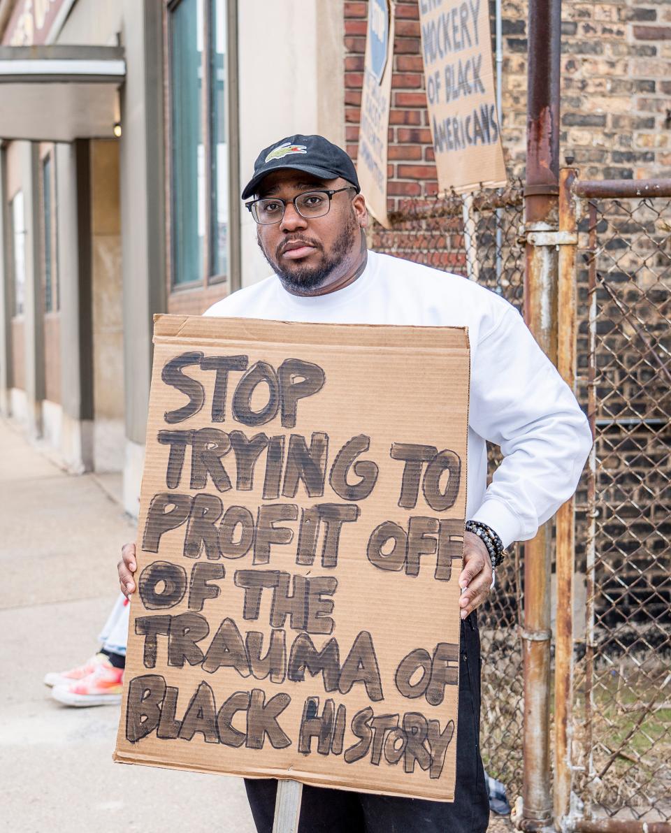 Vaun Mayes holds a sign protesting against the selling of racist items at Antiques on Pierce on Saturday March 4, 2023 in Milwaukee, Wis.