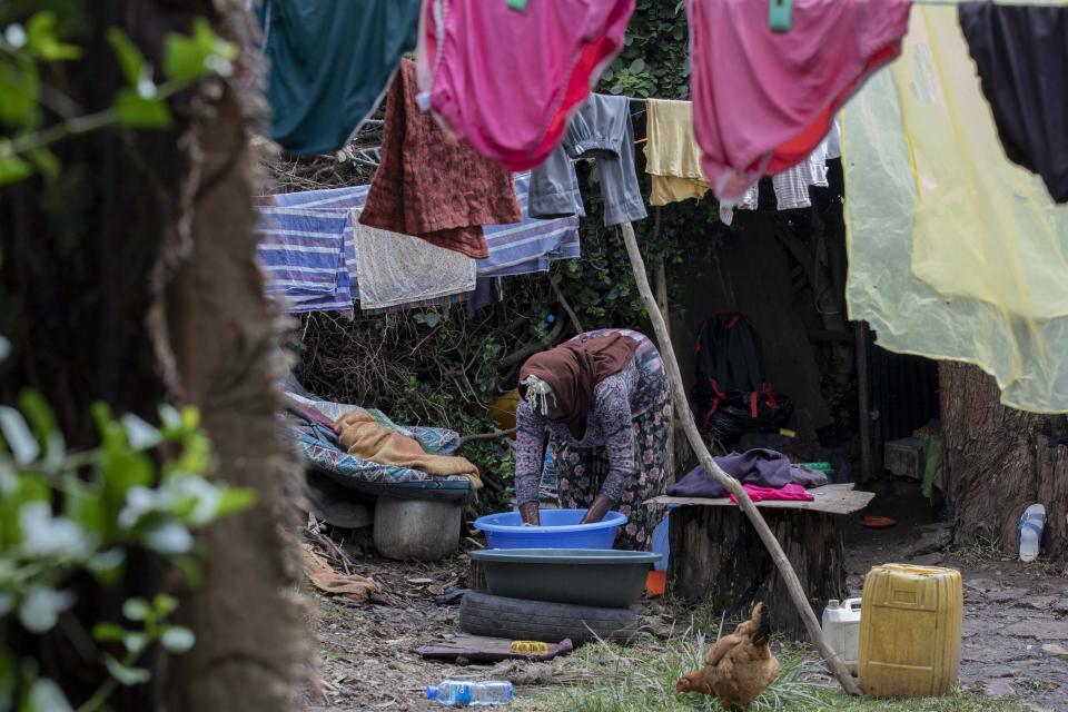 Amsale Hailemariam, una empleada doméstica que se quedó sin trabajo por el coronavirus, lava ropa afuera de su modesta vivienda en Adís Ababa, Etiopía, el 26 de junio del 2020. El Banco Mundial advierte sobre un pronunciado aumento de la pobreza extrema, sobre todo en África, como consecuencia de la pandemia. (AP Photo/Mulugeta Ayene)