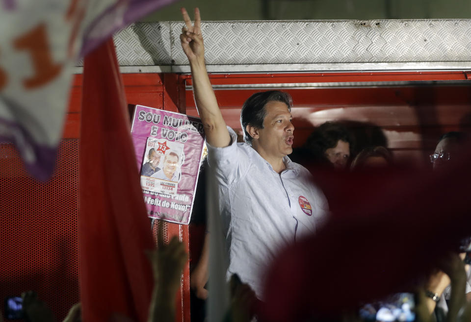 FILE - In this Sept. 25, 2018 file photo, presidential candidate for the Workers Party, Fernando Haddad, flashes a victory sign to supporters during a campaign event with women in Sao Paulo, Brazil. Haddad has promised to cut income taxes for workers making less than $1,216 a month and raise taxes on the rich for offset a drop in revenue. (AP Photo/Andre Penner, File)