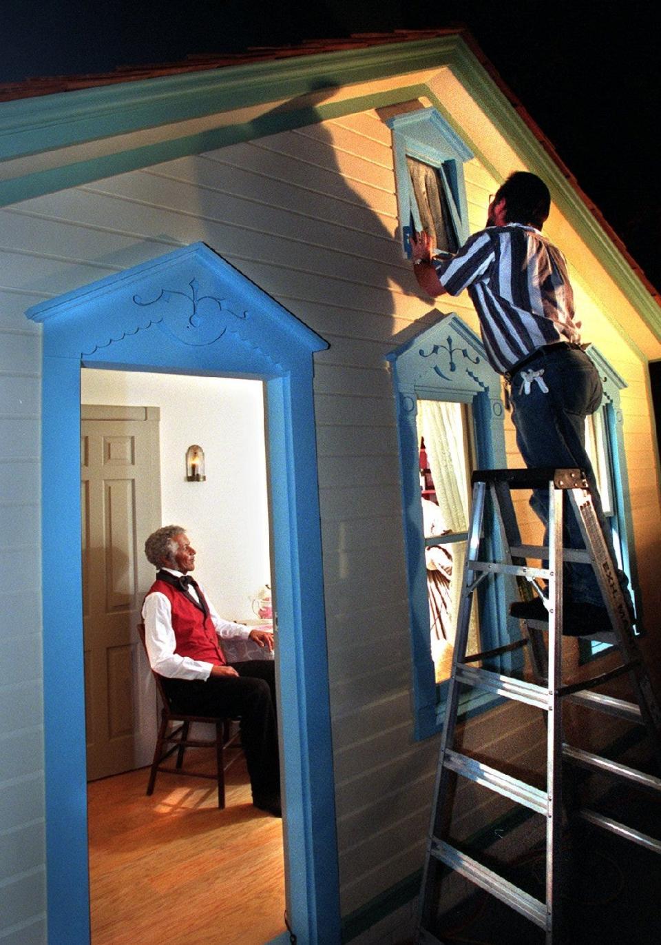 Mike Jeske, project designer for the new Watson Family House at the Milwaukee Public Museum, checks the fit of an upper window shortly before the exhibit, an addition to the Streets of Old Milwaukee, opened in February 2000.