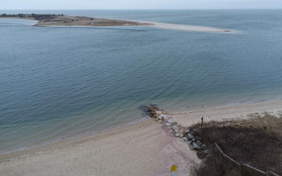 A view on Thursday looking southwest from the town landing at the end of Cross Street in Cotuit shows dredging pipe lining the east end of Dead Neck at the Cotuit Bay entrance where material from the project will be used for beach nourishment.