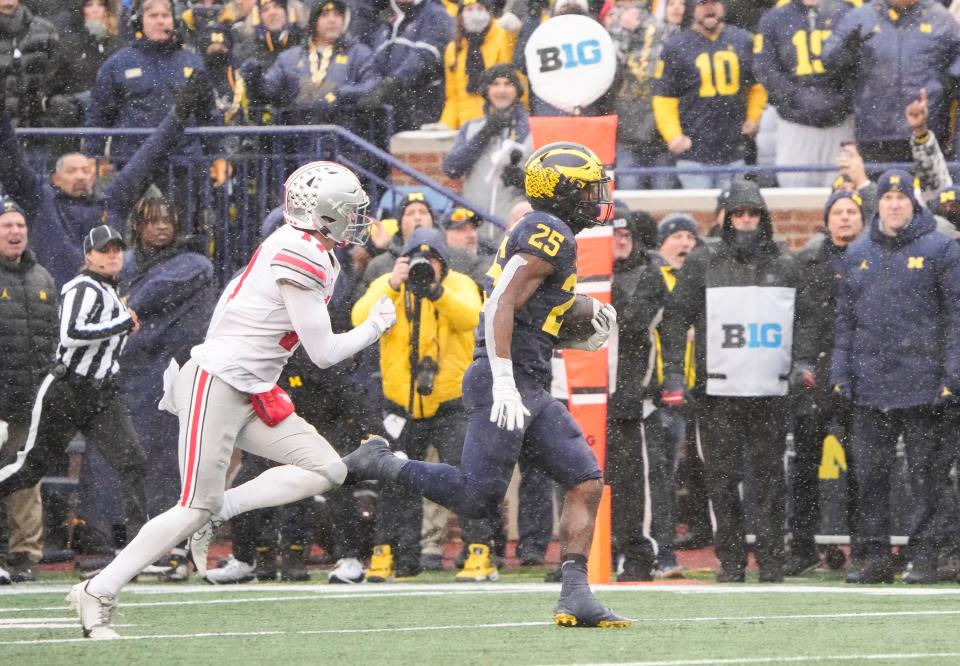 Ohio State Buckeyes safety Bryson Shaw (17) chases Michigan Wolverines running back Hassan Haskins (25) during the fourth quarter of the NCAA football game at Michigan Stadium in Ann Arbor on Saturday, Nov. 27, 2021. Ohio State lost 42-27.