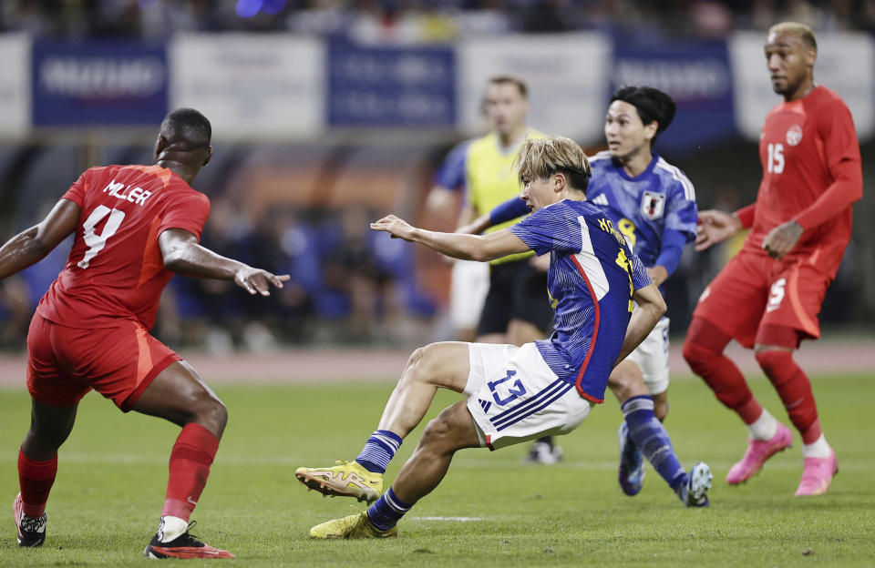 Keito Nakamura, center, of Japan, scores a goal past Kamal Miller, left, of Canada during a friendly soccer match in Niigata, northern Japan, Friday, Oct. 13, 2023. (Kyodo News via AP)