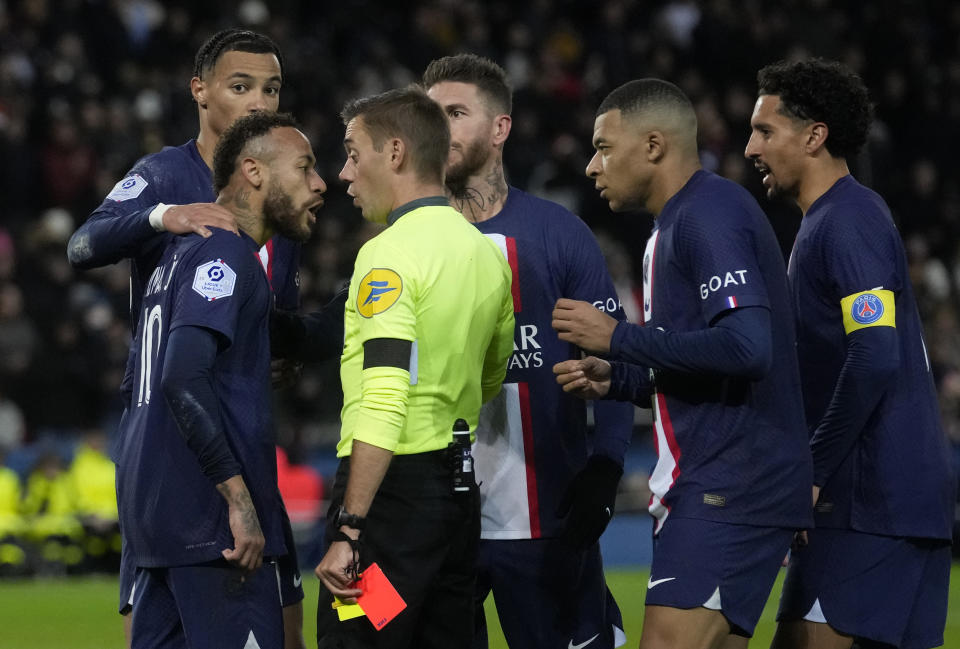 PSG's Neymar, front left, discusses with Referee Clement Turpin after being shown a red card during the French League One soccer match between Paris Saint-Germain and Strasbourg at the Parc des Princes in Paris, Wednesday, Dec. 28, 2022. (AP Photo/Thibault Camus)