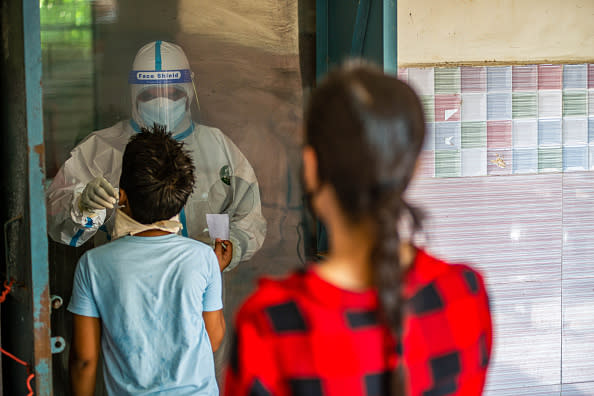 A health official collects a swab sample from a covid 19 suspected resident during a test in Delhi, India.