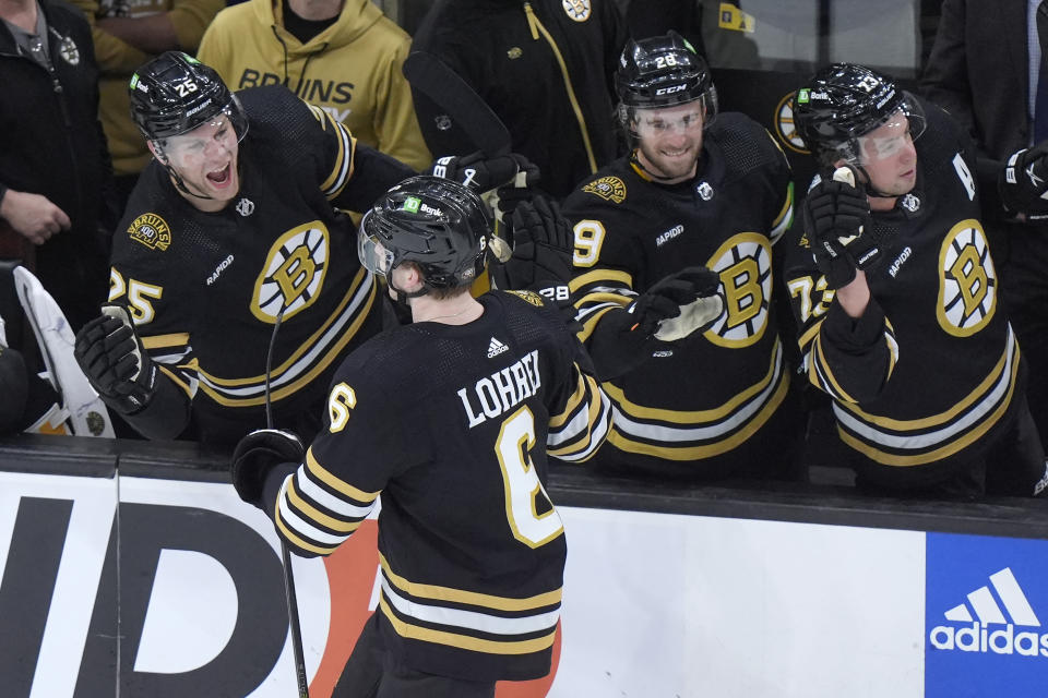 Boston Bruins defenseman Mason Lohrei (6) celebrates with teammates after scoring in the third period of an NHL hockey game against the Vegas Golden Knights, Thursday, Feb. 29, 2024, in Boston. (AP Photo/Steven Senne)