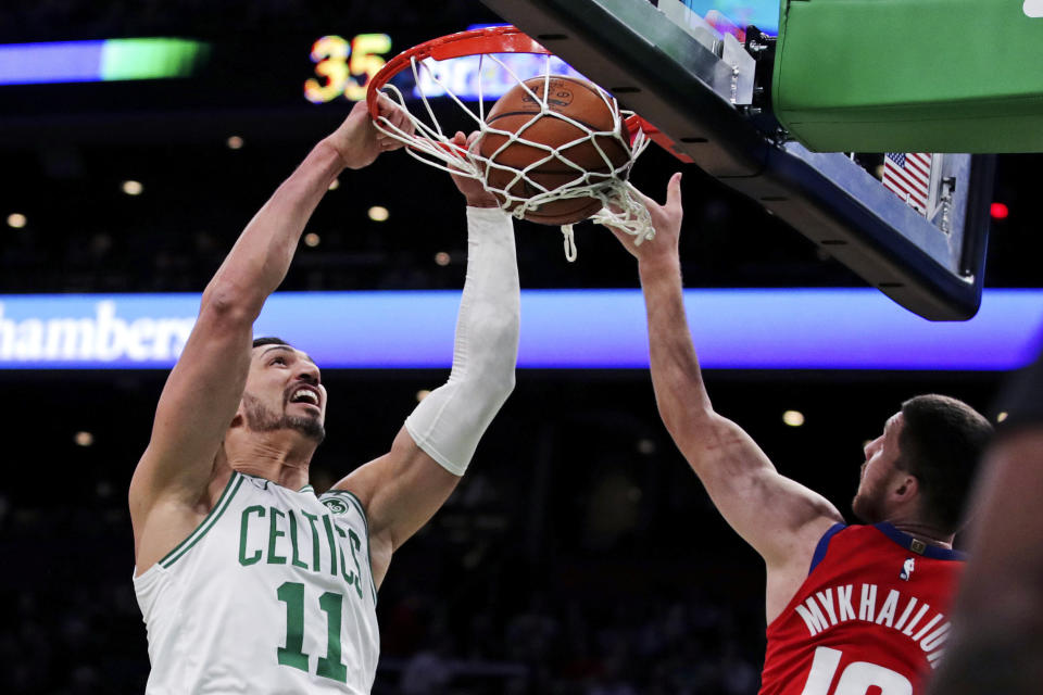 Boston Celtics center Enes Kanter (11) dunks next to Detroit Pistons guard Sviatoslav Mykhailiuk (19) during the first half of an NBA basketball game in Boston, Wednesday, Jan. 15, 2020. (AP Photo/Charles Krupa)