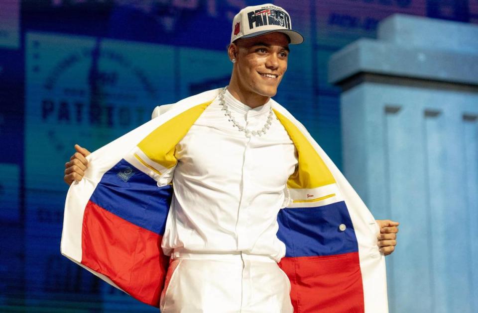 Oregon defensive back Christian Gonzalez flashes the inside of his suit, the colors of the Colombian flag, after being selected 17th overall by the New England Patriots during the NFL Draft outside of Union Station on Thursday, April 27, 2023, in Kansas City.