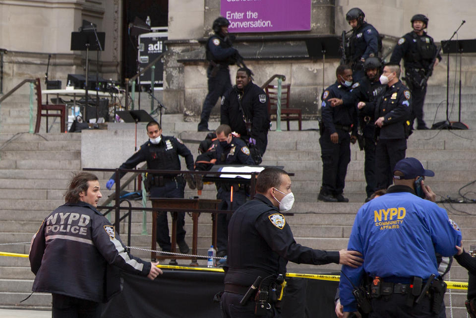 New York police officers carry a suspected gunman in a stretcher down the steps of Cathedral Church of St. John the Divine, Sunday, Dec. 13, 2020, in New York. A man was shot by police after shots rang out at the end of a Christmas choral concert on the steps of the Manhattan cathedral Sunday afternoon. It's unclear if the gunman was killed or if any others were injured. The shooting happened just before 4 p.m. at the church which is the mother church of the Episcopal Diocese of New York and seat of its bishop. (AP Photo/Ted Shaffrey)