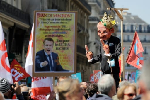 A protester holds a figure mocking Emmanuel Macron at the "The party for Macron" rally to protest the policies of the French president on the first anniversary of his election