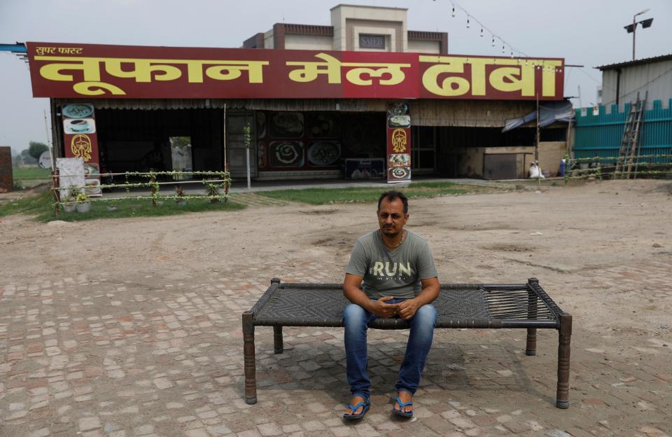 Vikas Malik, owner of a dhaba, a small restaurant, poses for a picture in front of his temporarily closed dhaba along a national highway in Murthal