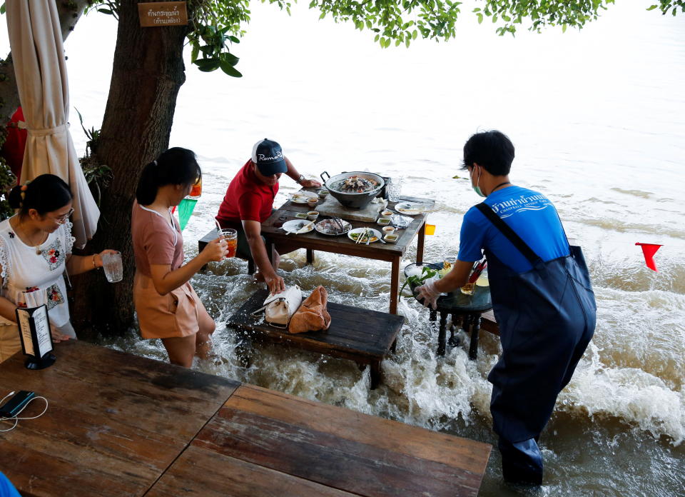 洪水湧入時，眾人七手八腳地站起來保護物品、穩住桌子。圖片來源：REUTERS
