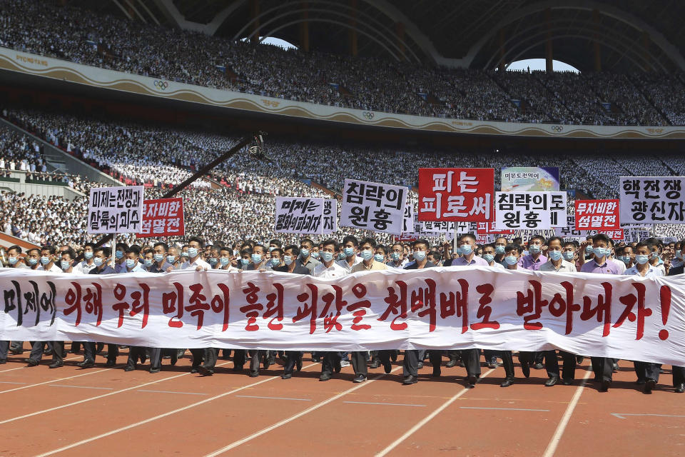 Pyongyang people take part in a demonstration after a mass rally to mark what North Korea calls "the day of struggle against U.S. imperialism" at the May Day Stadium in Pyongyang, North Korea Sunday, June 25, 2023. The signs read "Let us make the U.S. imperialists pay dearly for the blood shed by Korean nation!," "The U.S. is the chieftain of war and massacre," "merciless annihilation," "The U.S is the destroyer of peace," "chieftain of aggression," "blood to blood" and "nuclear war maniac." (AP Photo/Jon Chol Jin)