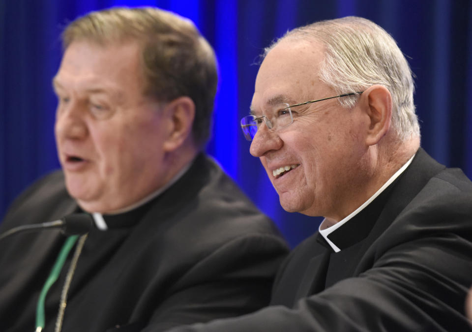 Archbishop Jose H. Gomez, right, of Los Angeles, smiles during a news conference after being elected president of the United States Conference of Catholic Bishops during their Fall General Assembly on Tuesday, Nov. 12, 2019 in Baltimore. (AP Photo/Steve Ruark)