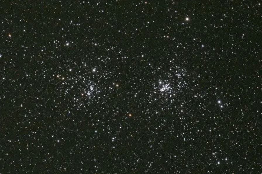 The Double Cluster of Perseus, NGC 869 and NGC 884, appears as a twin hazy patch to the naked eyes on a dark night. Andrew Cooper took this image. CC Attribution-Share Alike 3.0.