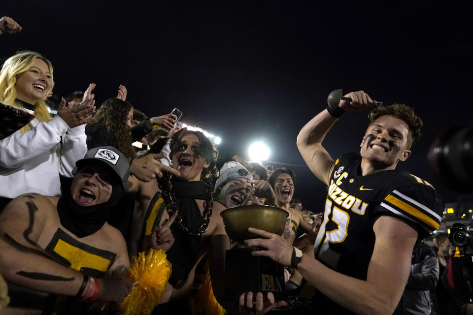 Missouri quarterback Brady Cook, right, celebrates with fans following an NCAA college football game against Florida Saturday, Nov. 18, 2023, in Columbia, Mo. Missouri won 33-31. (AP Photo/Jeff Roberson)