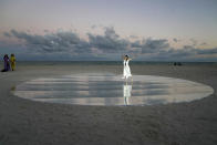 Dancer and choreographer Su Wen-Chi, of Taiwan, performs a dance titled "Moving Towards the Horizon" on the beach during Miami Art Week, Wednesday, Dec. 1, 2021, in Miami Beach, Fla. La Prairie skincare brand commissioned the dancer to interpret the encounter of light and water. Miami Art Week is an annual event centered around the Art Basel Miami Beach fair. (AP Photo/Lynne Sladky)