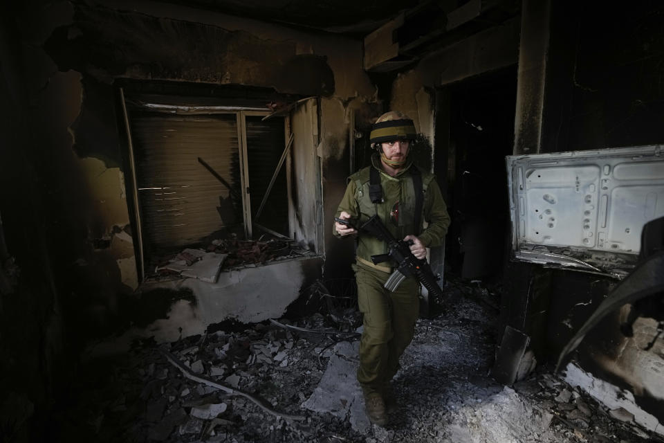 An Israeli soldier inspects a house damaged by Hamas militants in Kibbutz Be'eri, Israel, Tuesday, Oct. 17, 2023. The kibbutz was overrun by Hamas militants from the nearby Gaza Strip on Cot.7, when they killed and captured many Israelis. (AP Photo/Ariel Schalit)