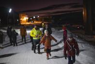Members of the Polargospel, the children's choir at the only church in Svalbard, arrive in Barentsburg, Norway, Saturday, Jan. 7, 2023. The choir traveled three hours each way by boat to mark Orthodox Christmas with the 40 children in Barentsburg, a village owned by Russia's Arctic mining company in the remote Norwegian territory. (AP Photo/Daniel Cole)