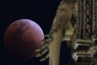 <p>A “super blood blue moon” is seen during an eclipse behind an elephant statue at a temple in Bangkok, Thailand, Jan. 31, 2018. (Photo: Athit Perawongmetha/Reuters) </p>