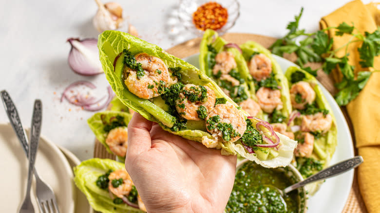 Holding shrimp lettuce wraps with chimichurri sauce