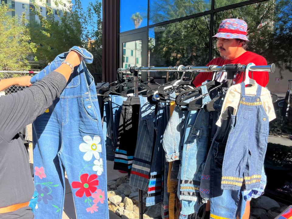 Filmmaker and vendor Luke Hunt speaks with a customer at a pop-up market at Cahokia SocialTech & Art Space in downtown Phoenix on Nov. 25, 2023.