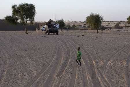 A boy passes in front of a convoy of French soldiers from Operation Barkhane on patrol in Timbuktu November 6, 2014. REUTERS/Joe Penney