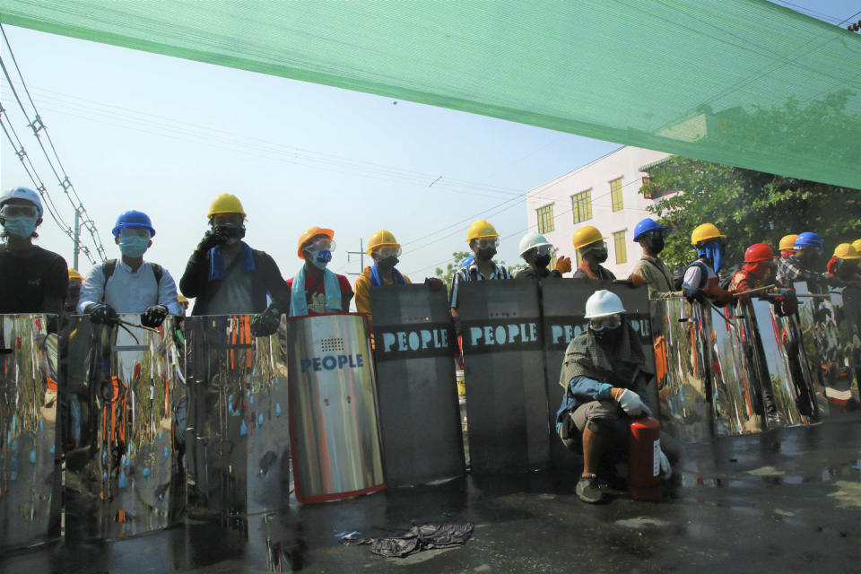 Anti-coup protesters with helmets and shields captured from police prepare for fire tear gas during a demonstration in Yangon, Myanmar, Saturday, March 6, 2021. Security forces in Myanmar used force again Saturday to disperse anti-coup protesters, a day after the U.N. special envoy urged the Security Council to take action to quell junta violence that this week left about 50 peaceful demonstrators dead and scores injured. (AP Photo)