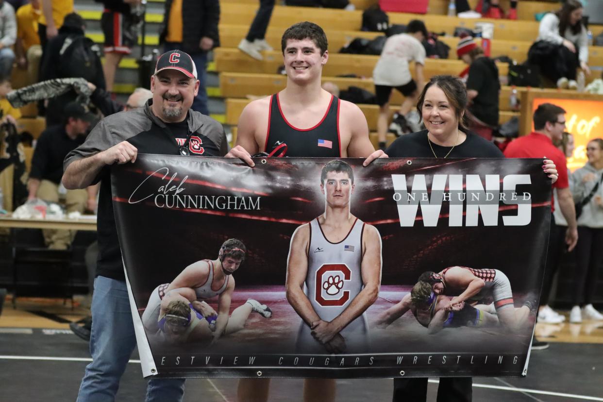 Caleb Cunningham celebrates his 100th career victory at the Firelands Conference meet with his mom, Tracey, and dad, Ray.
