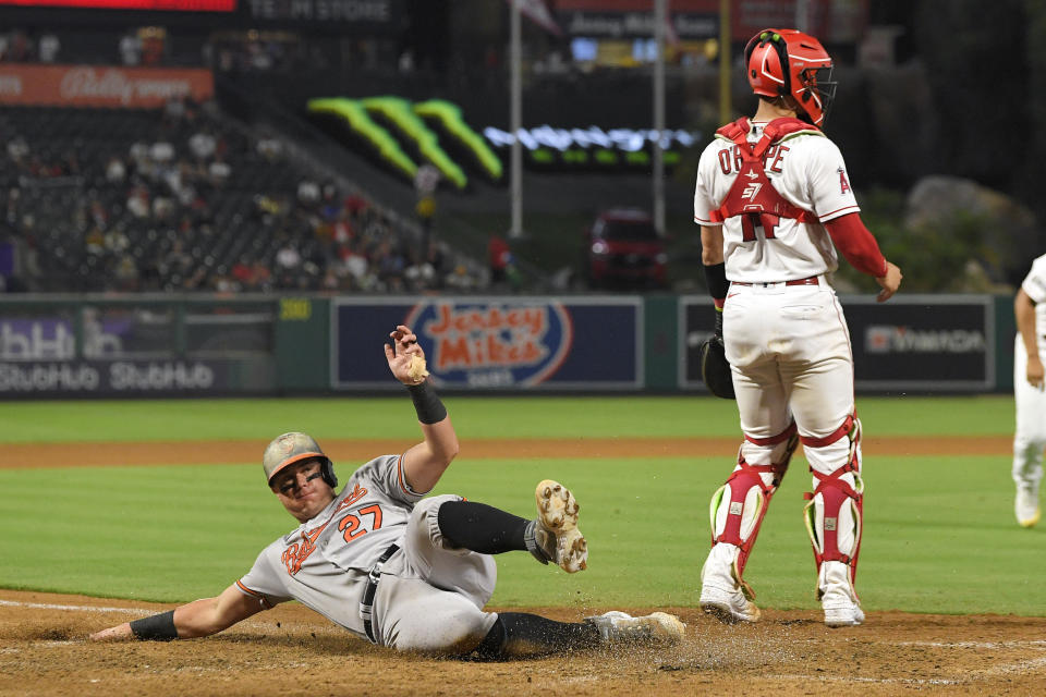 Baltimore Orioles' James McCann, left, scores on a single by Anthony Santander as Los Angeles Angels catcher Logan O'Hoppe stands at the plate during the sixth inning of a baseball game Wednesday, Sept. 6, 2023, in Anaheim, Calif. (AP Photo/Mark J. Terrill)