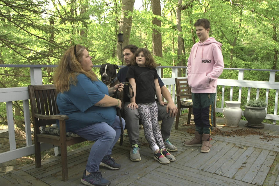 Brandy Swayze, 43, a coronavirus sufferer who created a Facebook survivors group after developing pneumonia, sits with her husband and children in Cabin John, Md., on April 27, 2020. She was hospitalized in late March and early April. Her fatigue comes and goes. Insomnia is another concern. “We’re just people who have more questions than anybody else about this thing because we’re going through it,” she says. (AP Photo/Federica Narancio)