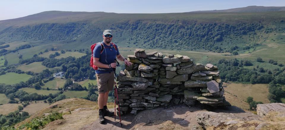 Man standing next to a heap of rocks