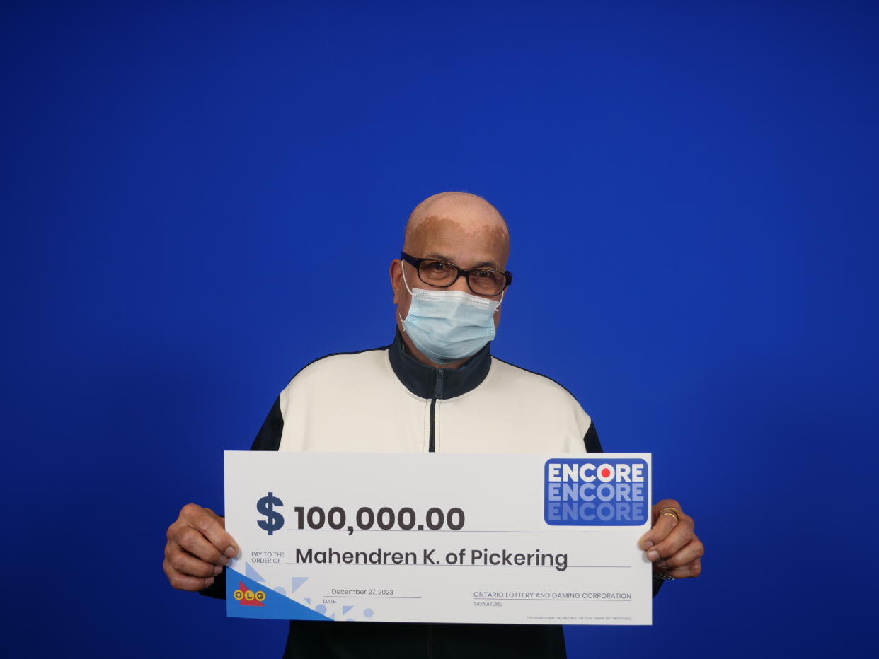 Man holding a $100,000 lottery cheque. 