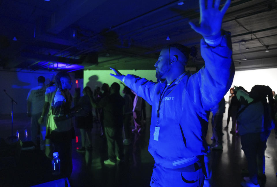 One of The Cove's seven co-founders, Aaron Dews, raises his arms in worship after a night of dancing on Saturday, Feb. 17, 2024, in Nashville, Tenn. The Cove is an alcohol free, 18-and-up, pop-up Christian nightclub started by seven friends in their 20s who sought to build a thriving community and a welcoming space for Christian adults outside houses of worship. (AP Photo/Jessie Wardarski)