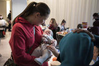 A helper holds baby Tuvia from an orphanage in Odesa, Ukraine, at a hotel in Berlin, Friday, March 4, 2022. More than 100 Jewish refugee children who were evacuated from a foster care home in war-torn Ukraine and made their way across Europe by bus have arrived in Berlin. (AP Photo/Steffi Loos)