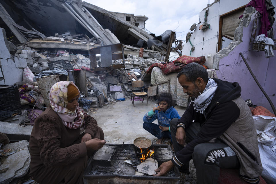 Members of the Al-Rabaya family break their fast during the Muslim holy month of Ramadan outside their destroyed home by the Israeli airstrikes in Rafah, Gaza Strip, Monday, March 18, 2024. (AP Photo/Fatima Shbair)