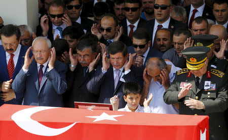 (L to R) Main opposition Republican People's Party (CHP ) Leader Kemal Kilicdaroglu, Speaker of Parliament Ismet Yilmaz, Prime Minister Ahmet Davutoglu, father of slain soldier Hamza Yildirim and Chief of Staff General Necdet Ozel pray in front of the flag-draped coffin of Yildirim during a funeral ceremony at Kocatepe mosque in Ankara, Turkey, July 31, 2015. REUTERS/Umit Bektas