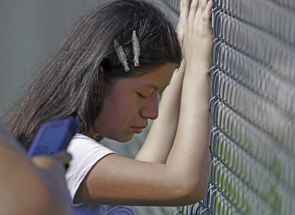 This young woman cries while standing outside the Koch Foods Inc., plant as U.S. immigration officials raid the plant in Morton, Miss., Wednesday, Aug. 7, 2019. U.S. immigration officials raided several Mississippi food processing plants on Wednesday and signaled that the early-morning strikes were part of a large-scale operation targeting owners as well as employees. (AP Photo/Rogelio V. Solis)