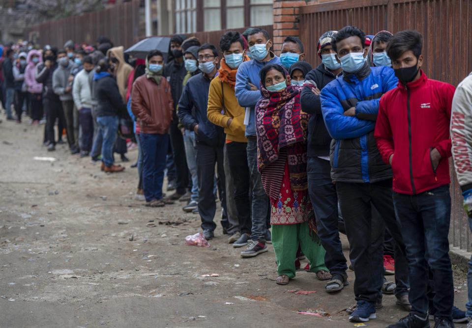 Nepalese people queue up to get vaccinated after government made vaccination cards mandatory for people to access public services in Kathmandu, Nepal, Thursday, Jan. 20, 2022. (AP Photo/Niranjan Shrestha)