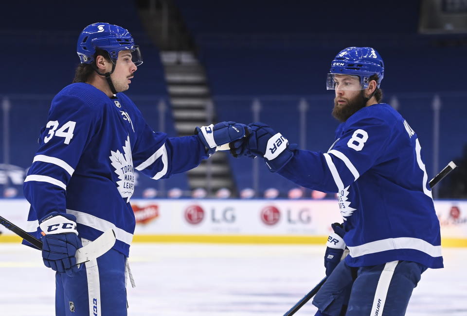 Toronto Maple Leafs forward Auston Matthews (34) celebrates his goal with Maple Leafs defenseman Jake Muzzin (8) after scoring against the Montreal Canadiens during the first period of an NHL hockey game Wednesday, April 7, 2021, in Toronto. (Nathan Denette/The Canadian Press via AP)