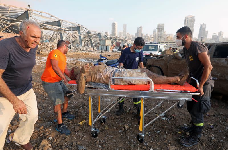 MATERIAL SENSIBLE. ESTA IMAGEN PUEDE LASTIMAR O PERTURBAR: Un hombre herido que quedó atrapado debajo de un vehículo después de una explosión en el área del puerto de Beirut es transportado en una camilla al hospital, en Beirut.