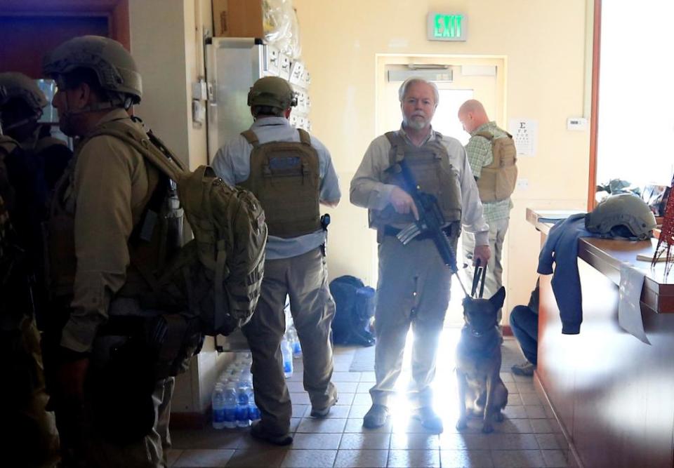 US embassy security staff seen through a window as protesters and militia fighters gather outside.