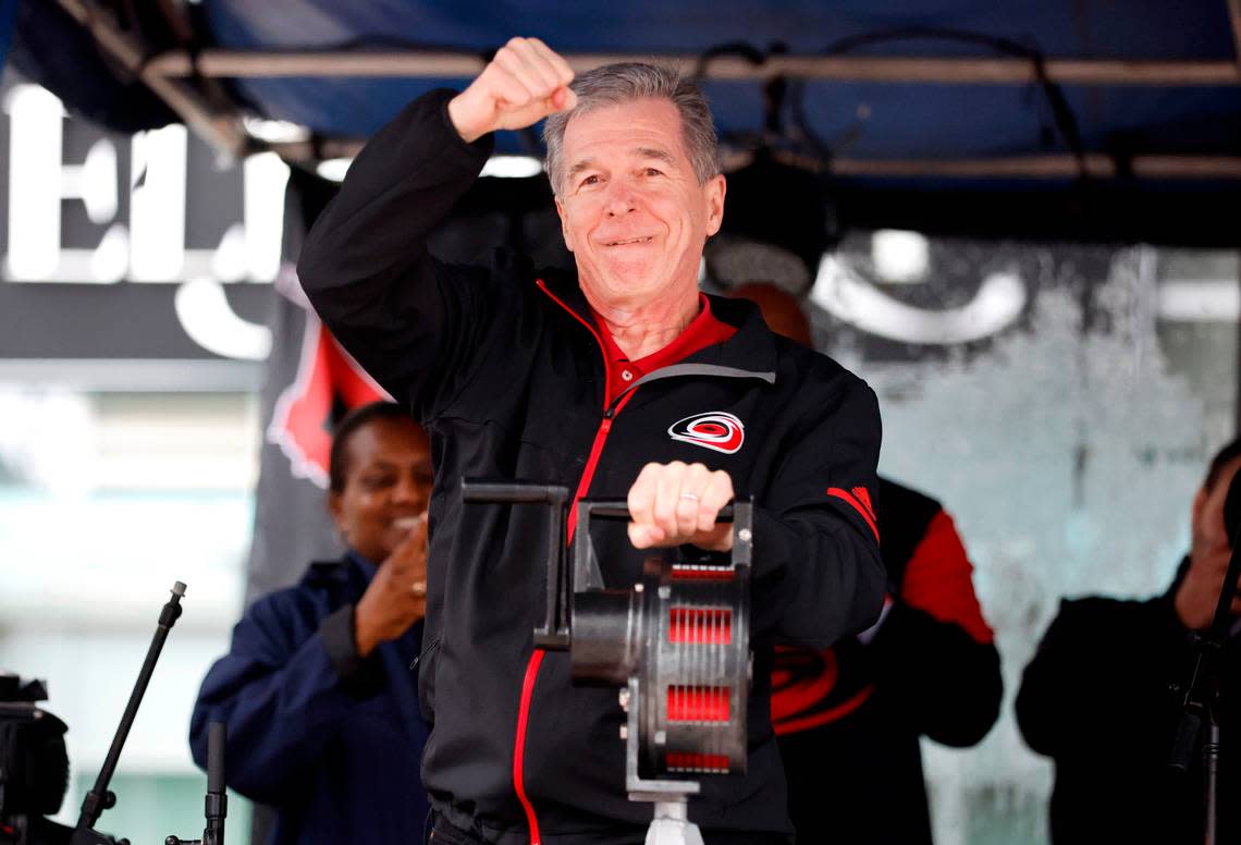 N.C. Governor Roy Cooper celebrates after cranking the warning siren to kickoff the Carolina Hurricanes Fan Fest in downtown Raleigh, N.C., Friday, Feb. 17, 2023. The festival is part of the celebrations before the Carolina Hurricanes’ Stadium Series outdoor game against the Washington Capitals Saturday at Carter-Finley Stadium.