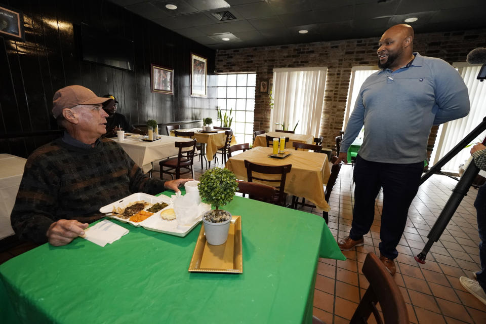 Timothy Norris, a licensed mental health counselor and owner of Mom's Dream Kitchen in Jackson, Miss., right, speaks with restaurant customer Keith Bradford on Feb. 14, 2023. Norris is concerned that proposals by the Mississippi Legislature, which is majority-white, would infringe on self-governance in the state's majority-Black capital city of Jackson. (AP Photo/Rogelio V. Solis)