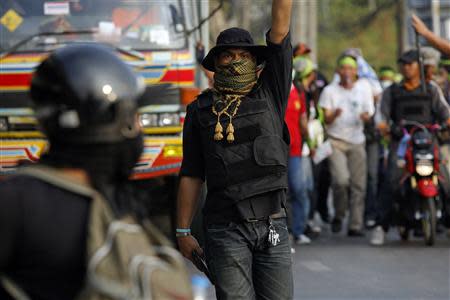 An anti-government protester armed with a pistol gestures during a gunfight between supporters and opponents of Thailand's government near the Laksi district office in Bangkok February 1, 2014. REUTERS/Damir Sagolj