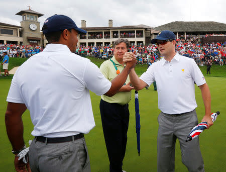 FILE PHOTO: U.S team member Tiger Woods (L) celebrates with teammate Zach Johnson after Woods defeated International player Richard Sterne of South Africa to win the Presidents Cup on the 18th hole during the Singles matches for the 2013 Presidents Cup golf tournament at Muirfield Village Golf Club in Dublin, Ohio October 6, 2013. REUTERS/Jeff Haynes